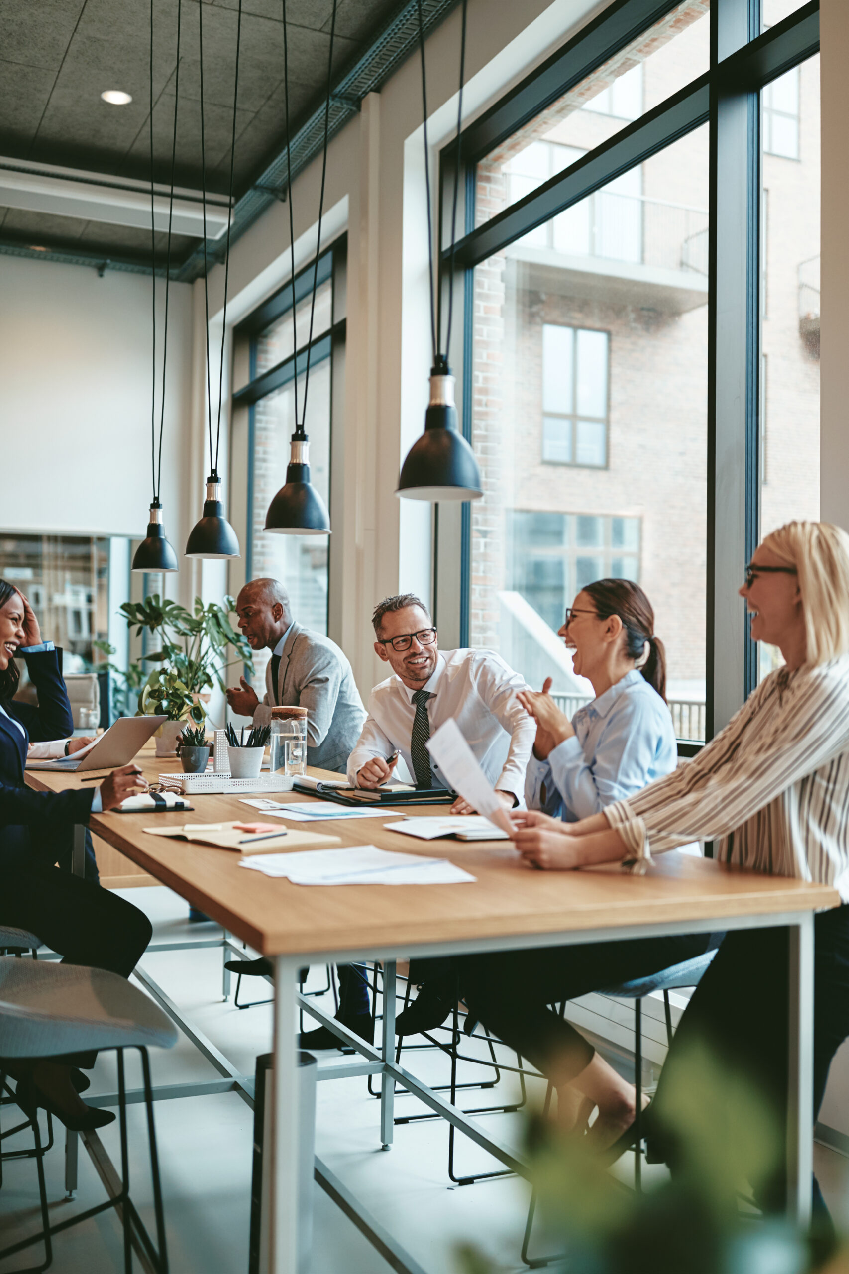 Laughing group of diverse businesspeople talking together around